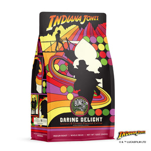 The front of a 12 ounce bag of Bones Coffee Company Daring Delight coffee inspired by Lucasfilm Indiana Jones. Its flavor is coconut and caramel, and it has Indiana Jones on the art.