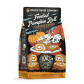 The front of a 12 ounce bag of Bones Coffee Company Frosted Pumpkin Roll coffee. Its flavor is frosted pumpkin roll, and it has skeletal hands cutting into a pumpkin roll on a table with pumpkins in the background on the art.