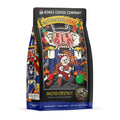 The front of a 12 ounce bag of Bones Coffee Company Nutcracker’s Revenge coffee. Its flavor is roasted chestnut, and it has a skeleton dressed as Santa running from a fire-breathing nutcracker on the art.