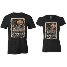The front of the women's and men's Peaches and Scream tee shirts. It is colored black and has the art of the Peaches and Scream coffee on them. It showcases a skeleton on a couch in a pair of boxers with peaches on them while a peach with a skeletal face and hands leans towards them on the art.