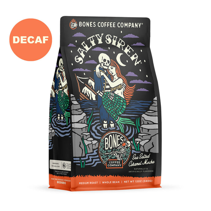 The front of a 12 ounce bag of Bones Coffee Company Salty Siren coffee. Its flavor is sea salted caramel mocha, and it has a skeleton dressed up as a sailor holding a mermaid on the art. There is a sticker that says decaf.