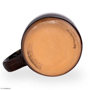 The bottom of the Bones Coffee Company Toffee Treasure hand thrown mug. It is brown colored and has a white glaze on top of it.