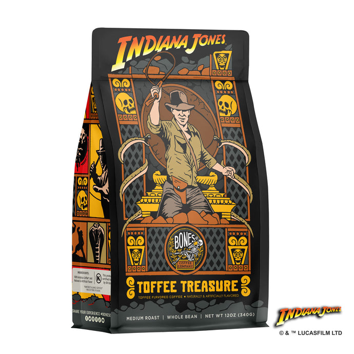 The front of a 12 ounce bag of Bones Coffee Company Toffee Treasure coffee inspired by Lucasfilm Indiana Jones. Its flavor is toffee and it has Indiana Jones cracking his whip on the art.