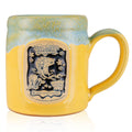 The front of the Bones Coffee Company Bikini Bottom Brew hand thrown mug with SpongeBob SquarePants and Gary the snail on the golden medallion. It is inspired by SpongeBob SquarePants. The mug is yellow colored and has a blue and white glaze on top of it.