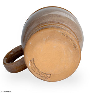 The bottom of a tan colored mug inspired by Lucasfilm Indiana Jones.