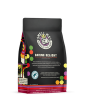 The back of a 12 ounce flavored coffee bag named Daring Delight. The Rain Forest Alliance page on the lower left of the back of the bag, and it says to squeeze and sniff at the top of the bag. Below the squeeze and sniff text is the name Daring Delight.