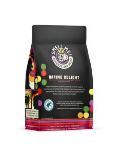 The back of a 12 ounce flavored coffee bag named Daring Delight. The Rain Forest Alliance page on the lower left of the back of the bag, and it says to squeeze and sniff at the top of the bag. Below the squeeze and sniff text is the name Daring Delight.