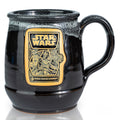The front of the Bones Coffee Company Dark Side Chocolate Truffle hand thrown mug with the Dark Side Chocolate Truffle coffee art on the golden medallion. The mug is black colored with a white glaze on top. It is inspired by Lucasfilm’s Star Wars.