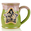 The front of the Bones Coffee Company Goofy Goober Sundae hand thrown mug with Squidward and Plankton on the golden medallion. It is inspired by SpongeBob SquarePants. The mug is moss green colored and has a pink and white glaze on top of it.