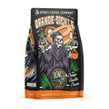 The front of a 12 ounce bag of Bones Coffee Company Orange-Sickle flavored coffee. It is orange vanilla cream flavored, and It has a skeleton holding an orange popsicle over its shoulder dressed as the grim reaper on the art. 