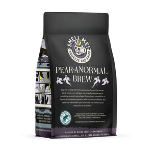 The back of a 12 ounce flavored coffee bag named Pear-anormal Brew. The Rain Forest Alliance page on the lower left of the back of the bag, and it says to squeeze and sniff at the top of the bag. Below the squeeze and sniff text is the name Pear-anormal Brew.