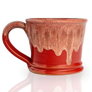 The back of the White Russian mug that is red colored with a sand-white glaze on top of it.