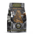 The front of a 12 ounce bag of Bones Coffee Company Wookiee Cookie flavored coffee. Its flavor is chocolate chip cookie, and it is inspired by Lucasfilm’s Star Wars. The art shows Chewy, Lea, and Han Solo on it.