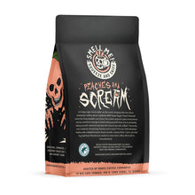 The back of a 12 ounce flavored coffee bag named Peaches and Scream. The Rain Forest Alliance page on the lower left of the back of the bag, and it says to squeeze and sniff at the top of the bag. Below the squeeze and sniff text is the name Peaches and Scream.