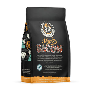 The back of a 12 ounce flavored coffee bag named Maple Bacon. The Rain Forest Alliance page on the lower left of the back of the bag, and it says to squeeze and sniff at the top of the bag. Below the squeeze and sniff text is the name Maple Bacon.