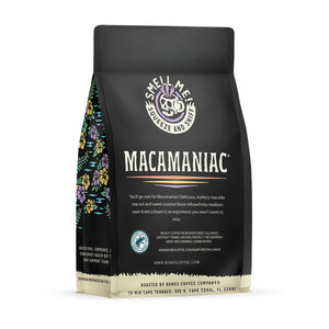The back of a 12 ounce flavored coffee bag named Macamaniac. The Rain Forest Alliance page on the lower left of the back of the bag, and it says to squeeze and sniff at the top of the bag. Below the squeeze and sniff text is the name Macamaniac.