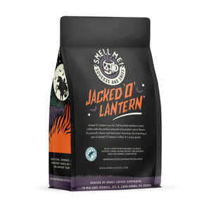 The back of a 12 ounce flavored coffee bag named Jacked O’ Lantern. The Rain Forest Alliance page on the lower left of the back of the bag, and it says to squeeze and sniff at the top of the bag. Below the squeeze and sniff text is the name Jacked O’ Lantern.