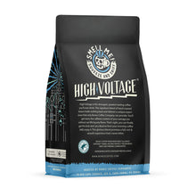 The back of a 12 ounce coffee bag named High Voltage. The Rain Forest Alliance page on the lower left of the back of the bag, and it says to squeeze and sniff at the top of the bag. Below the squeeze and sniff text is the name High Voltage.