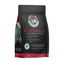 The back of a 12 ounce flavored coffee bag named Guatemala. The Rain Forest Alliance page on the lower left of the back of the bag, and it says to squeeze and sniff at the top of the bag. Below the squeeze and sniff text is the name Guatemala.