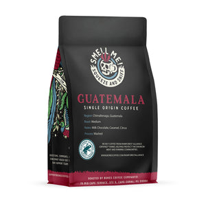The back of a 12 ounce flavored coffee bag named Guatemala. The Rain Forest Alliance page on the lower left of the back of the bag, and it says to squeeze and sniff at the top of the bag. Below the squeeze and sniff text is the name Guatemala.