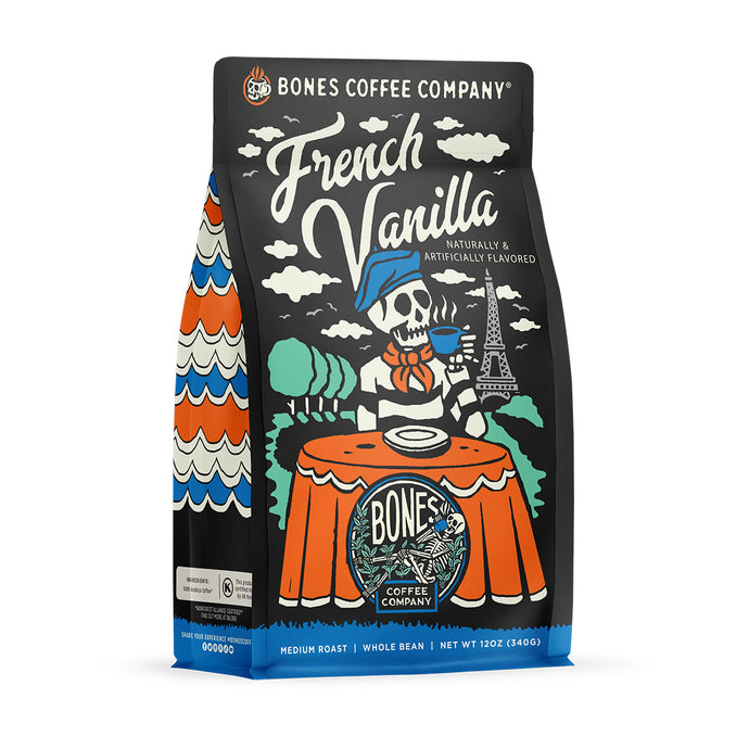 The front of a 12 ounce bag of Bones Coffee Company French Vanilla coffee. Its flavor is a creamy vanilla, and it has a skeleton wearing a beret with a black and white striped shirt drinking coffee before the Eiffel tower on the art.