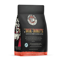 The back of a 12 ounce flavored coffee bag named From Dusk til Dawn. The Rain Forest Alliance page on the lower left of the back of the bag, and it says to squeeze and sniff at the top of the bag. Below the squeeze and sniff text is the name From Dusk til Dawn.
