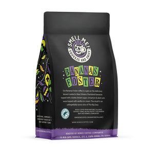The back of a 12 ounce flavored coffee bag named Bananas Foster. The Rain Forest Alliance page on the lower left of the back of the bag, and it says to squeeze and sniff at the top of the bag. Below the squeeze and sniff text is the name Bananas Foster.