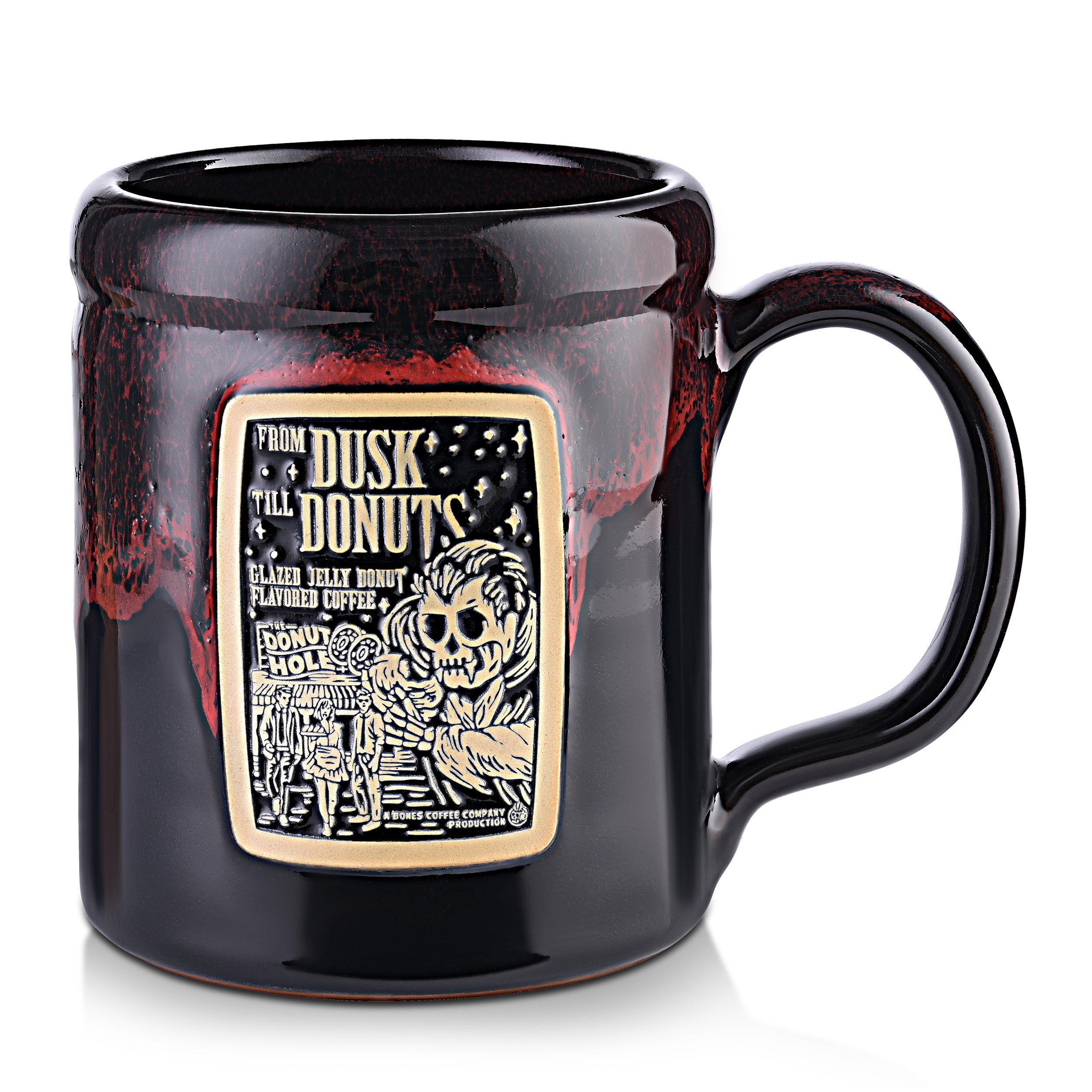 The front of the Bones Coffee Company From Dusk til Dawn hand thrown tankard with the From Dusk til Dawn coffee art on the golden medallion. The mug is black colored with a red glaze on top.