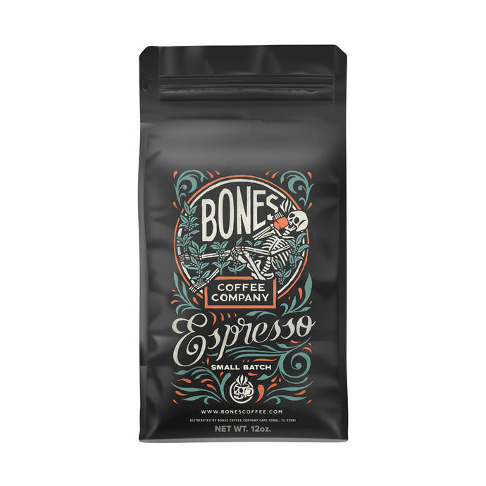 The front of a 12 ounce coffee bag for espresso. The Bones Coffee Company logo is on it and has a skeleton lounging in greenery and sipping on coffee.