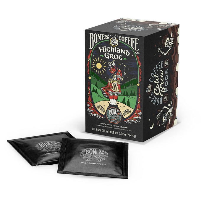 A box and cold brew pods of flavored coffee named Highland Grog. Its flavor is caramel and butterscotch, and its art shows a skeleton wearing a kilt playing bagpipes on a hill.