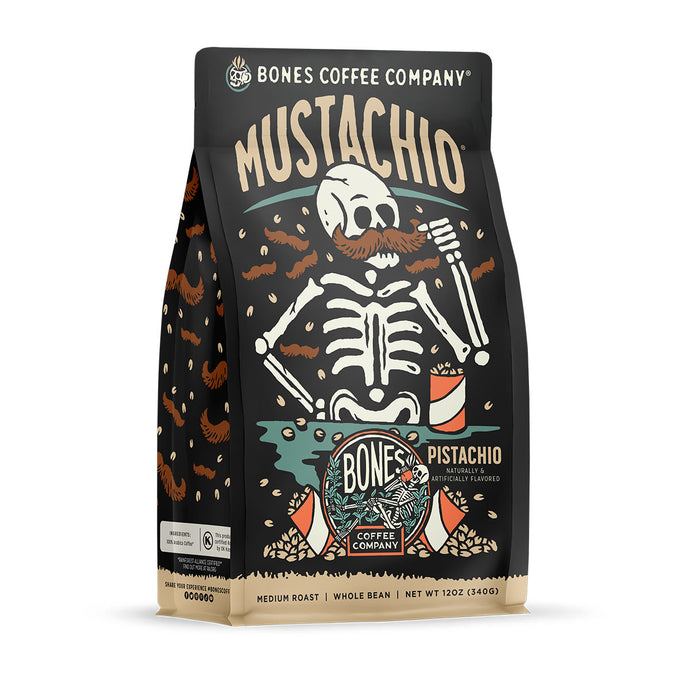 The front of a 12 ounce bag of Bones Coffee Company Mustachio coffee. Its flavor is pistachio and macadamia nut, and it has a skeleton with a large handlebar mustache with pistachios around them on the art.