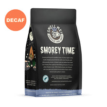 The back of a 12 oz flavored coffee bag named S’morey Time. The Rain Forest Alliance page on the lower left of the back of the bag, and it says to squeeze and sniff at the top of the bag. Below the squeeze and sniff text is the name S’morey Time. A sticker says decaf.