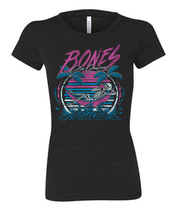 The front of the women's Retro Summer tee shirt. They're colored black and has art of a skeleton sipping coffee in a hammock between two palm trees before a retro colored sun.