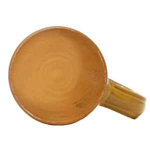 The bottom of the Wunderbones tankard. It is mustard colored with a cinnamon-white glaze on top of it.