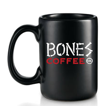 The back of the Army of Dark Chocolate mug that is colored black. The Bones Coffee Company logo is on it and has Bones Coffee Co on it with bones spelled with bones.